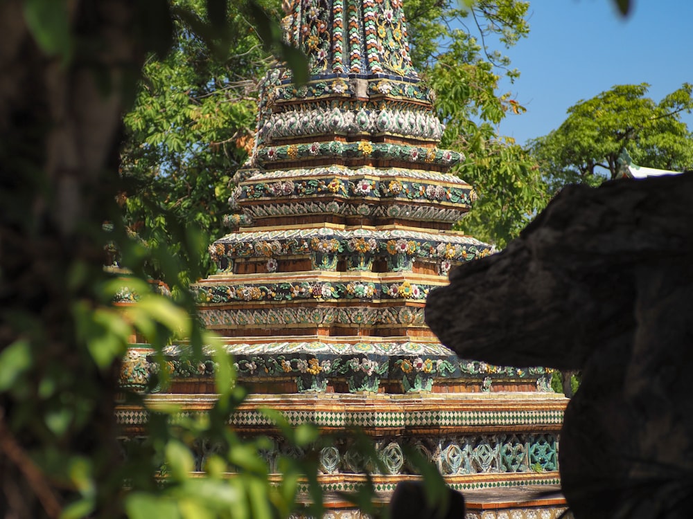 gold and green temple near green trees during daytime