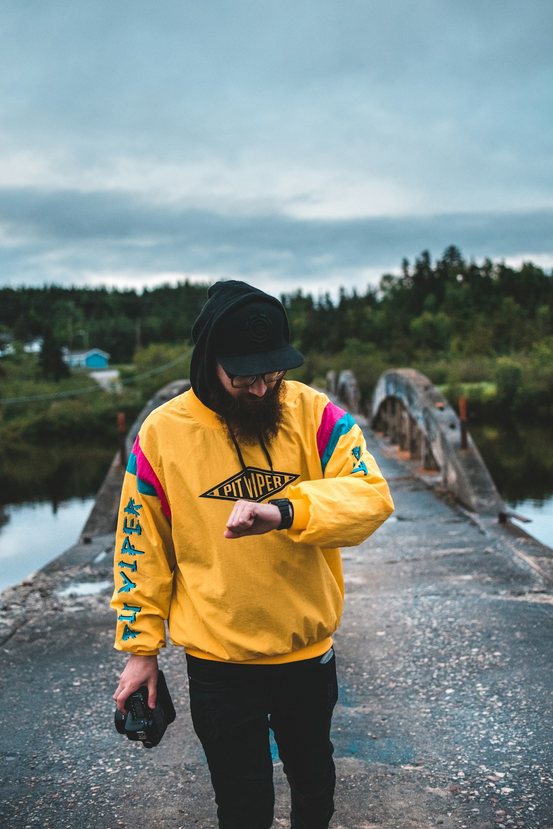 man in yellow jacket and black knit cap standing on road during daytime