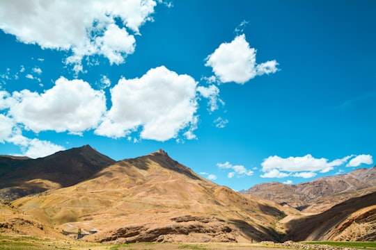 brown mountain under blue sky and white clouds during daytime in Spiti Valley India