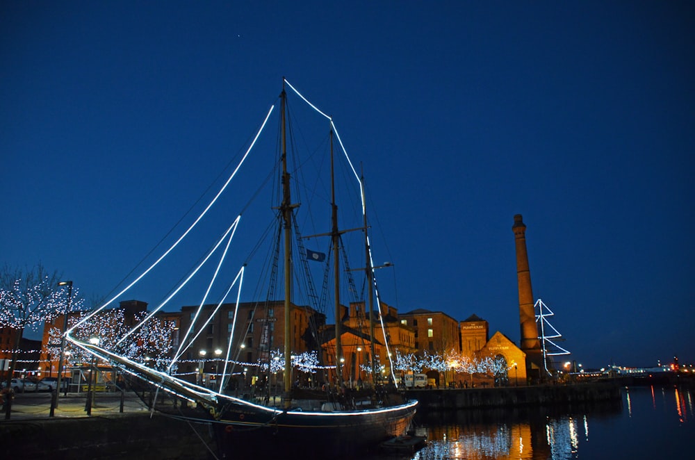 Barca bianca e blu sull'acqua vicino al ponte durante la notte