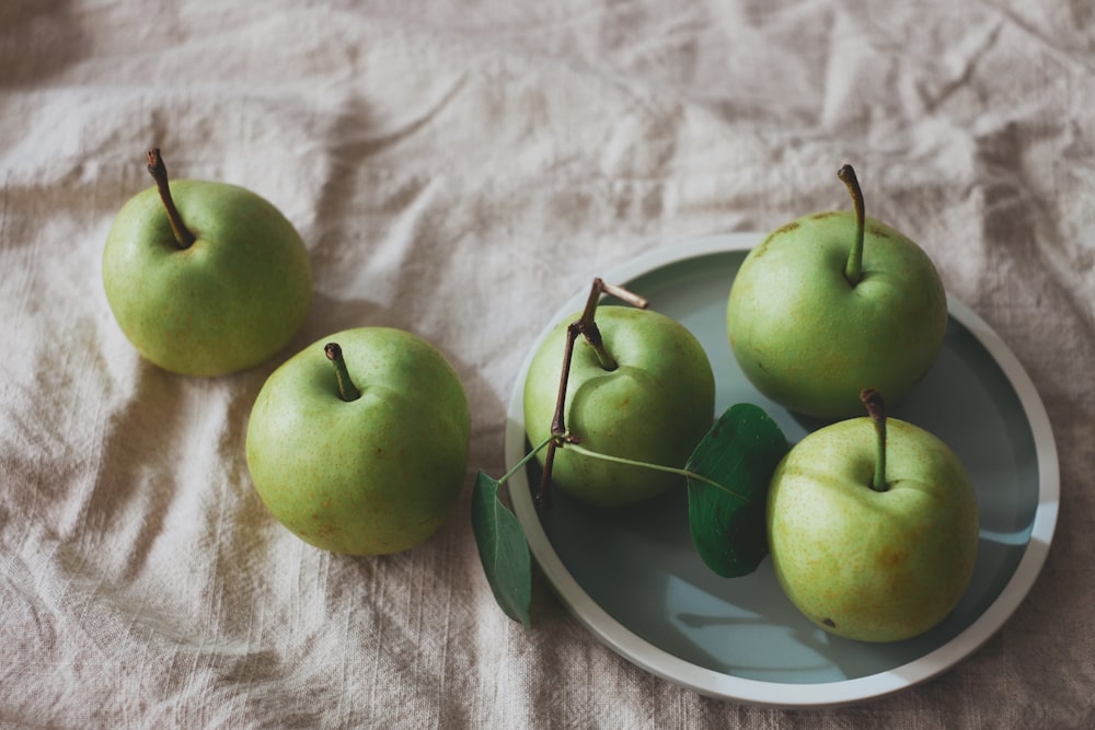 manzanas verdes en placa de cerámica blanca y azul