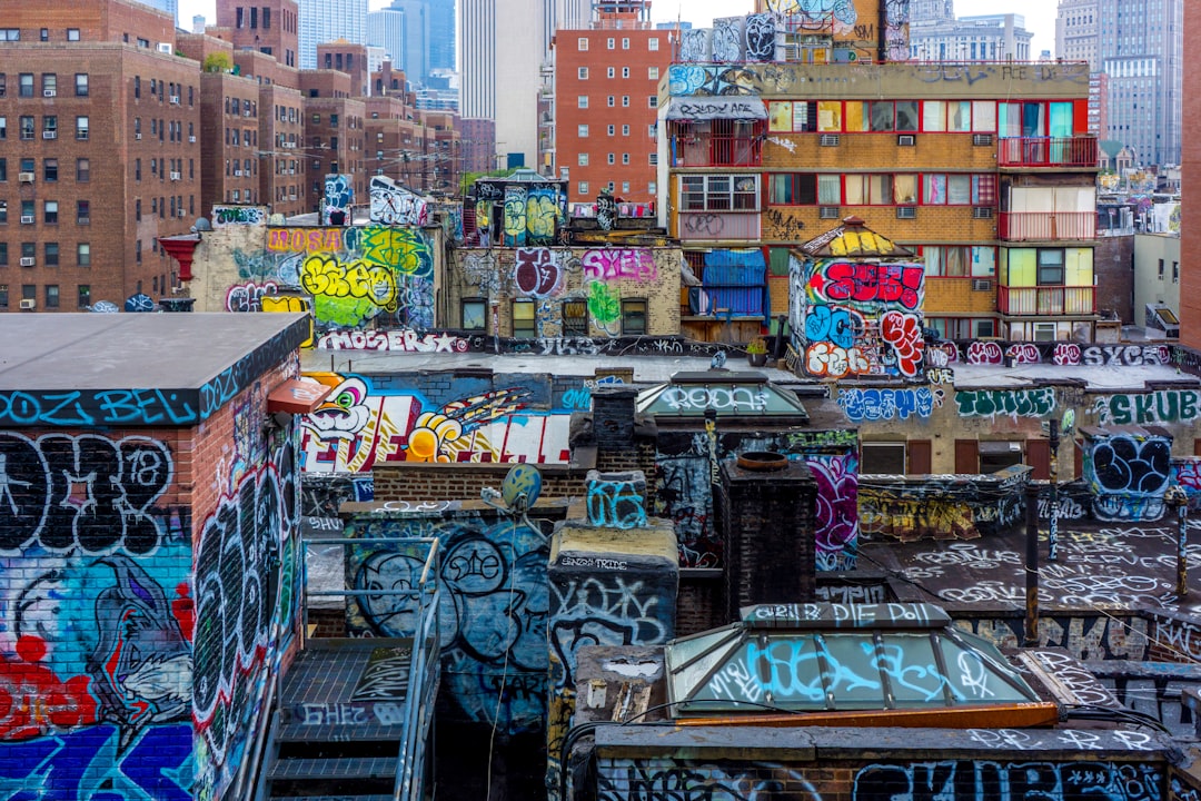 brown and white concrete building, Colorful graffities on buildings