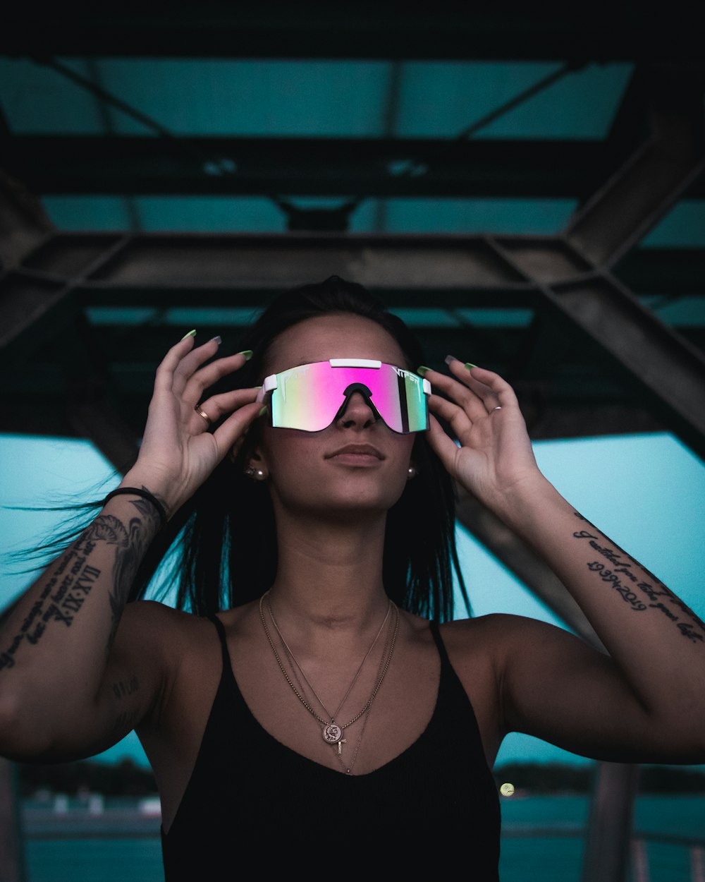 woman in black tank top wearing pink framed sunglasses