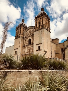 brown concrete building under blue sky and white clouds during daytime