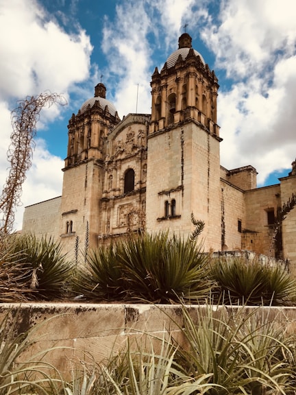brown concrete building under blue sky and white clouds during daytime