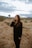 brunette woman in black long sleeve shirt standing on brown field during daytime