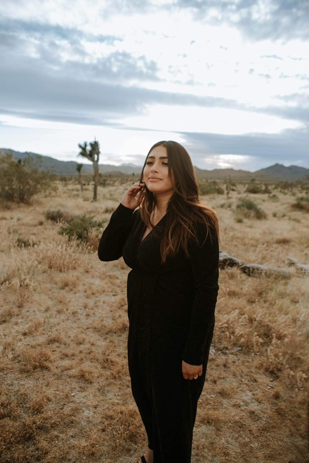 woman in black long sleeve shirt standing on brown field during daytime