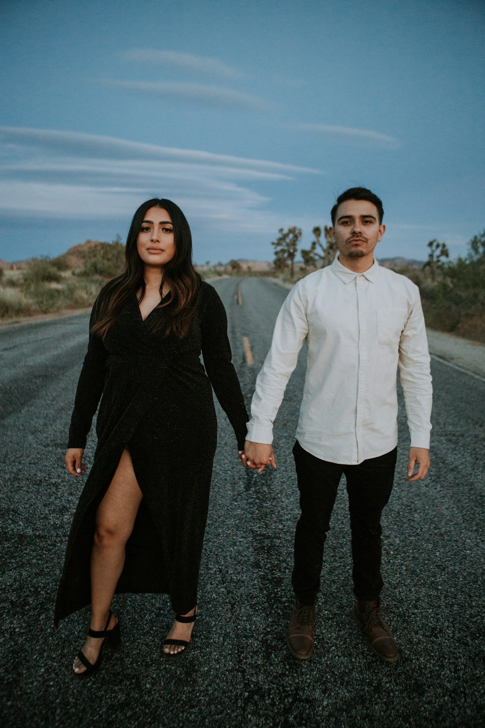 man in white dress shirt standing beside woman in black dress