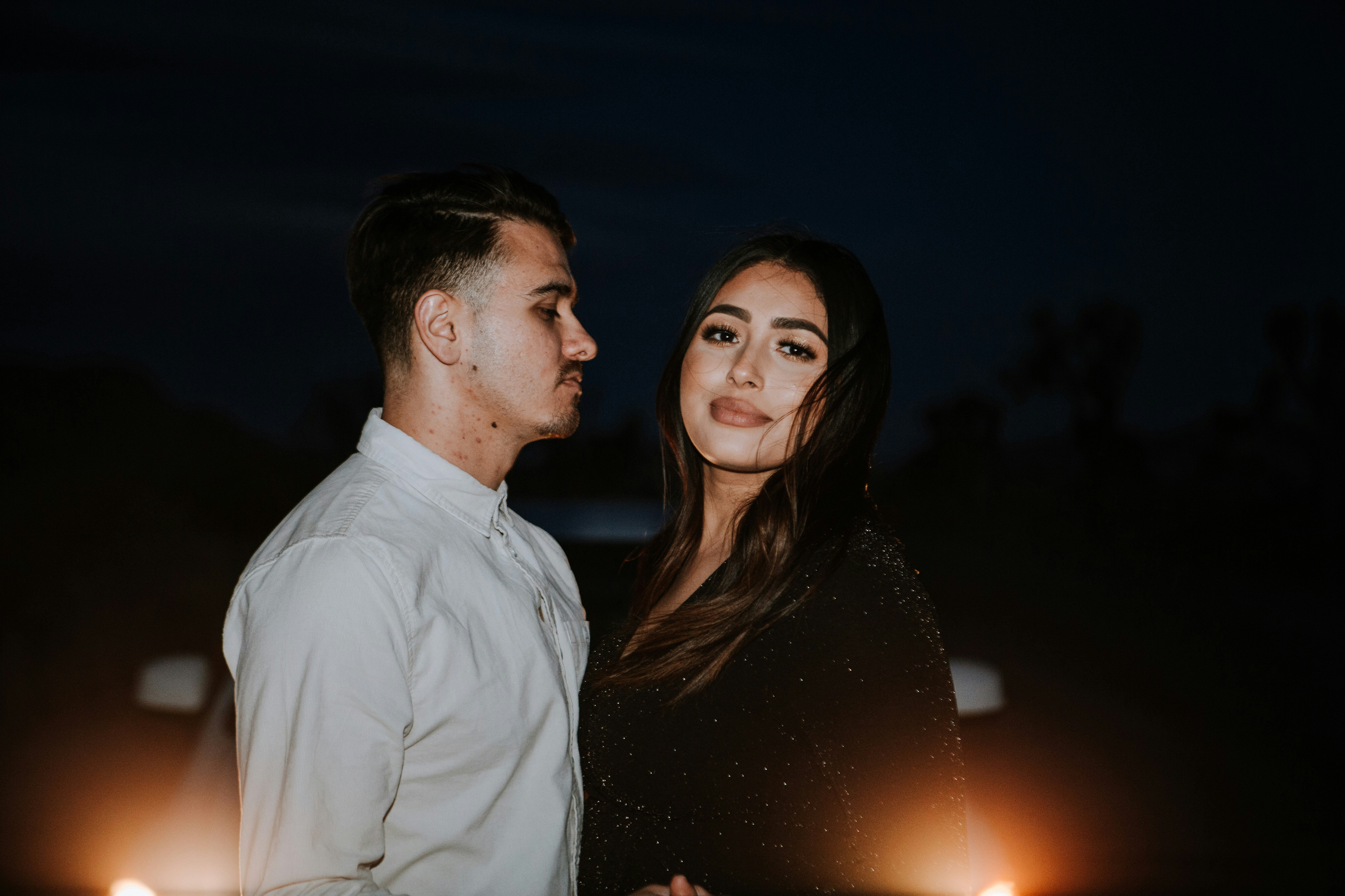 man in white dress shirt beside woman in black dress