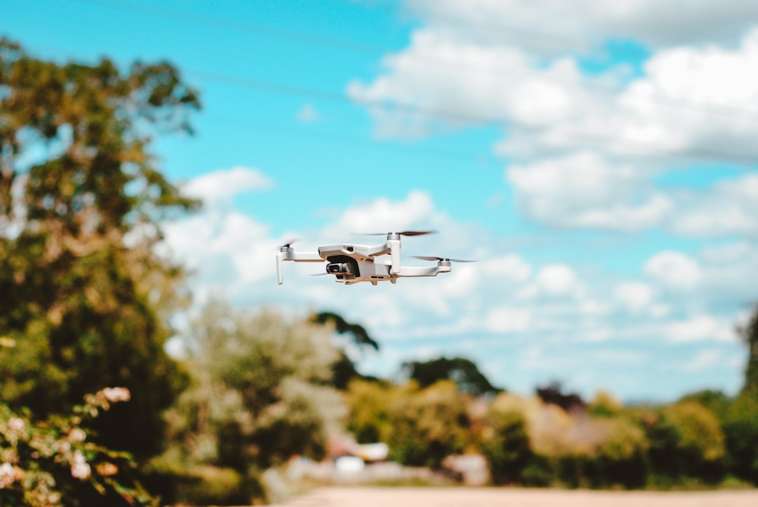 white drone flying in the sky during daytime