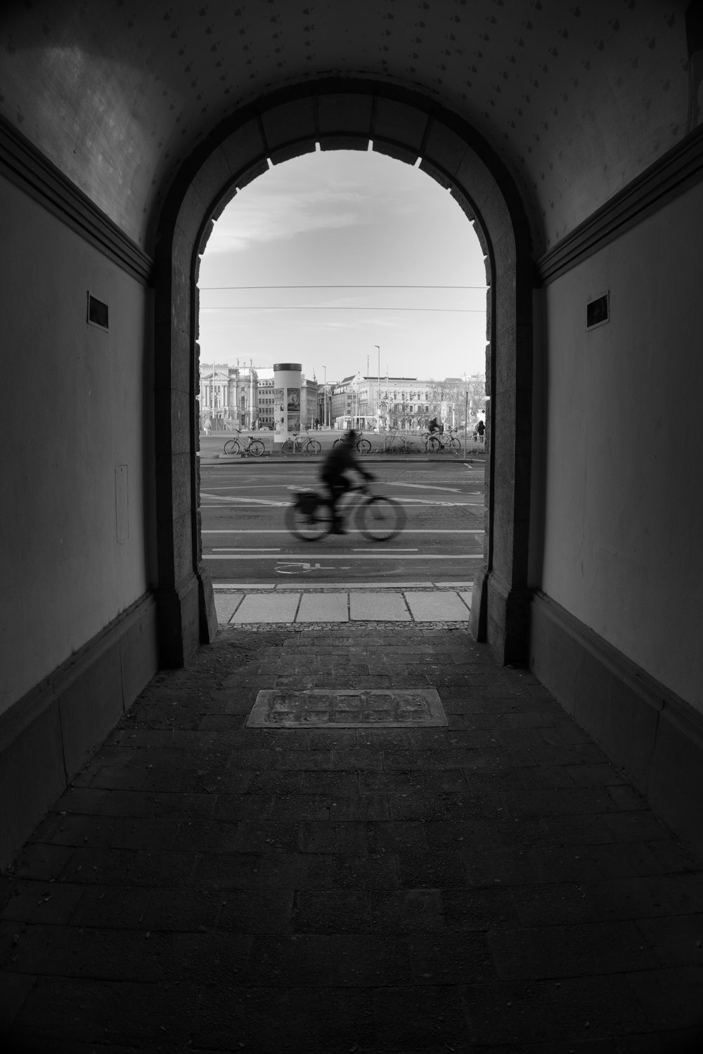 a black and white photo of a person riding a bike