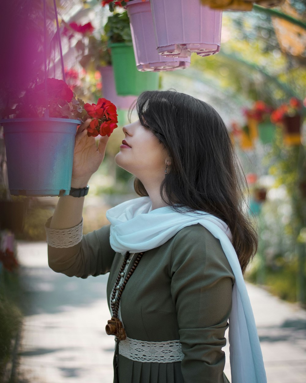 woman in green jacket holding pink plastic cup