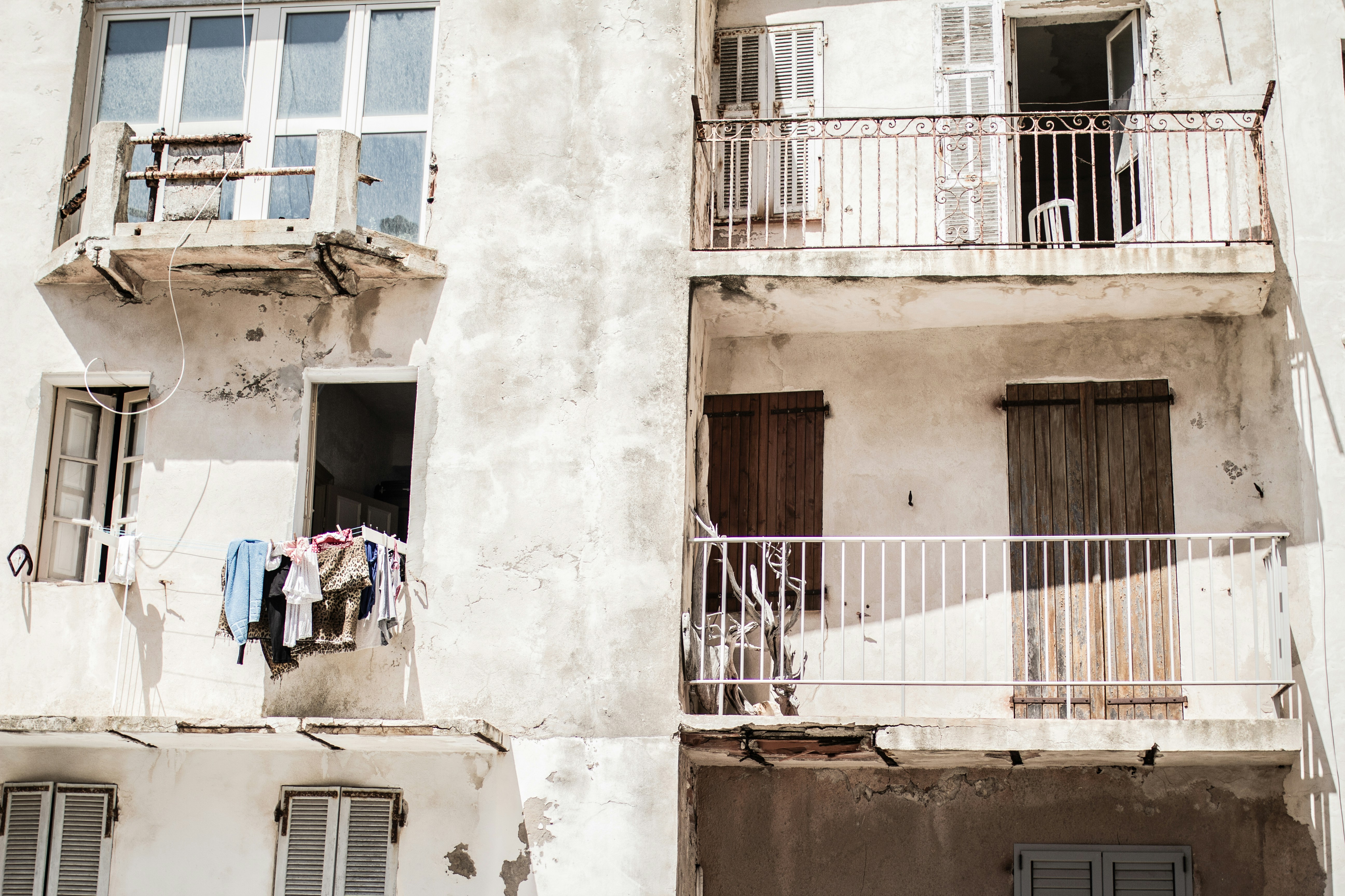 mujer con camisa azul y jeans azules de pie junto a un edificio de hormigón marrón durante el día