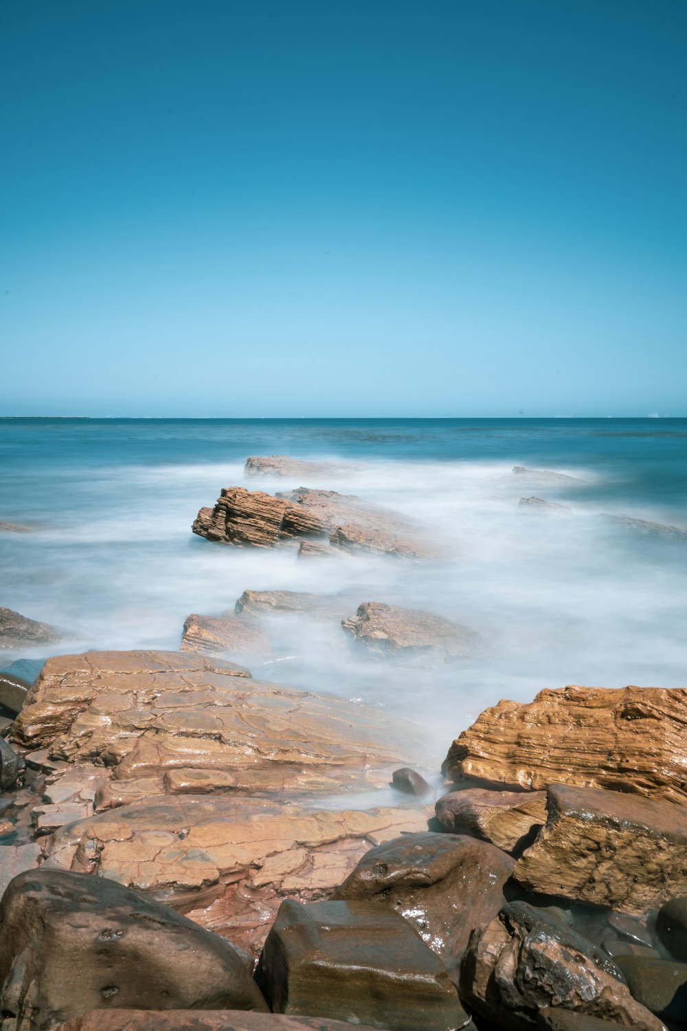 brown rock formation near sea during daytime