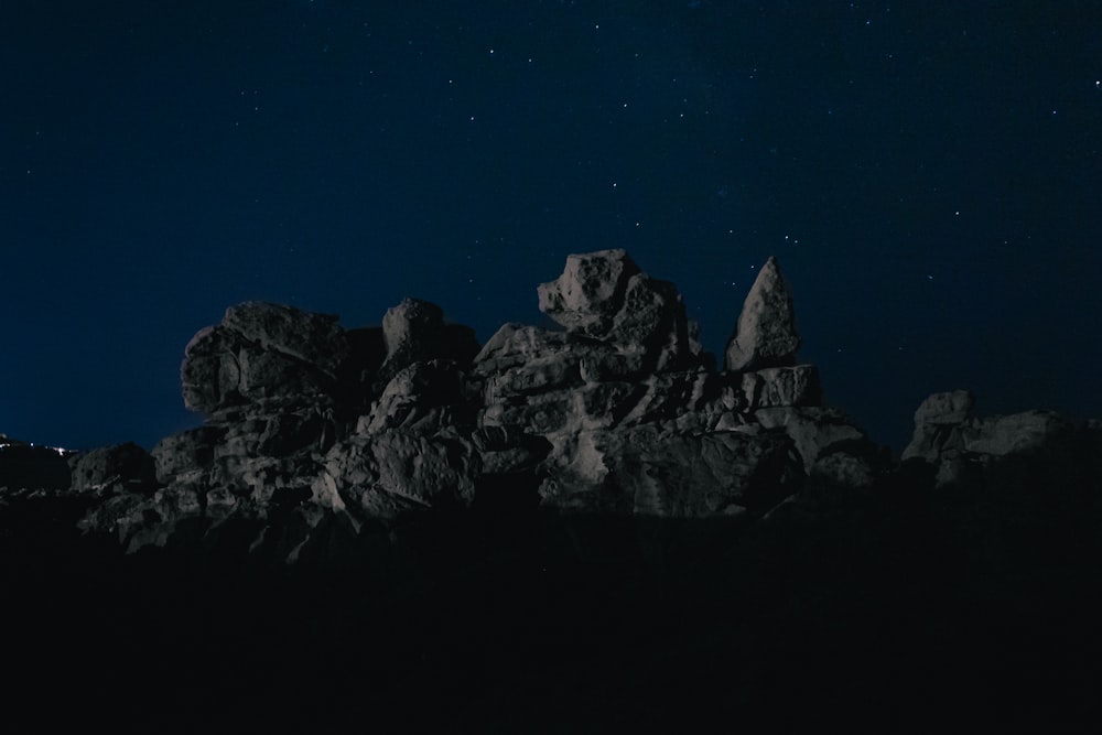 black rocky mountain under blue sky during night time