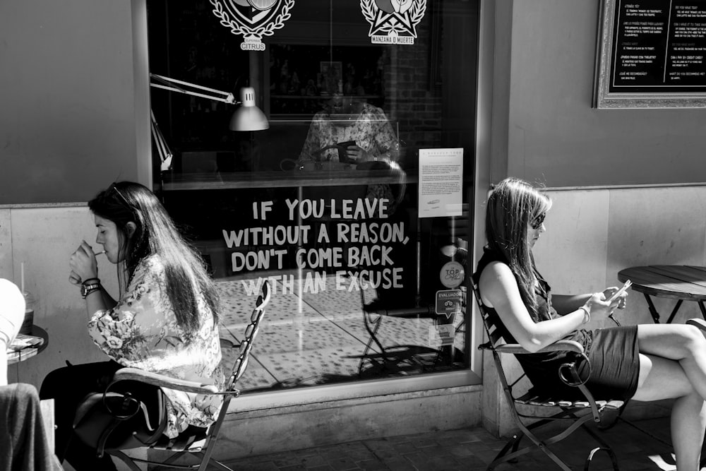 grayscale photo of woman sitting on chair