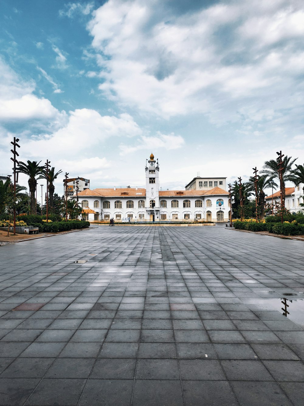 white and brown concrete building under white clouds during daytime