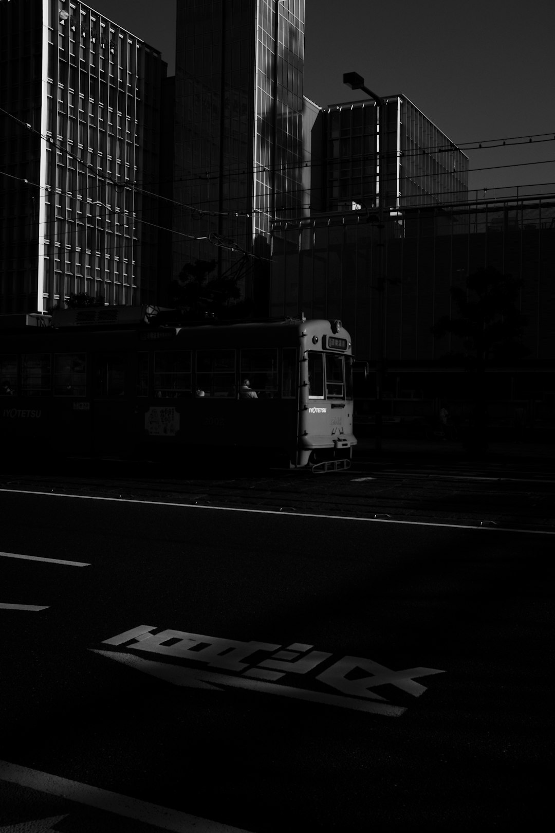 grayscale photo of white bus on road