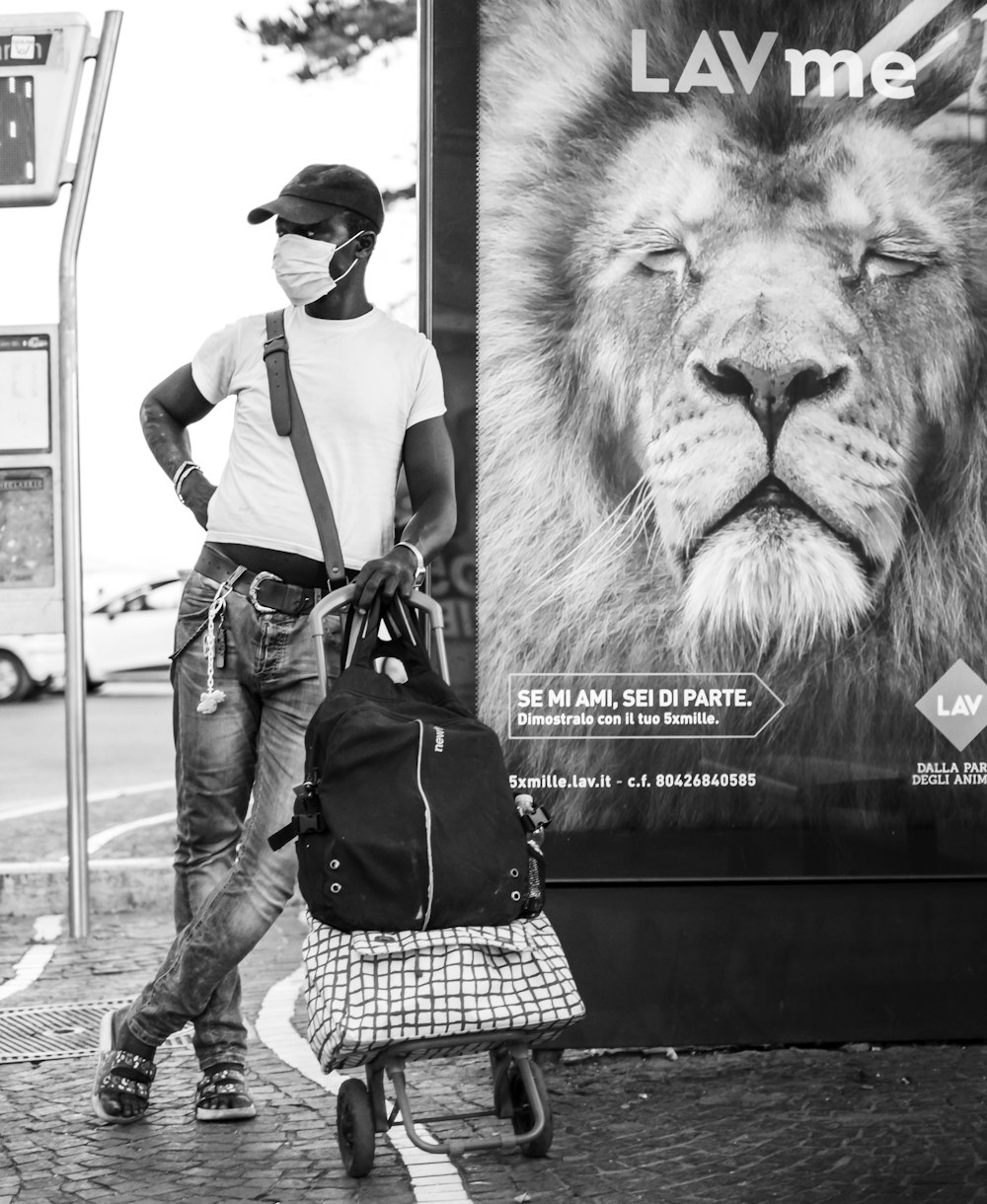 man in black and white checkered dress shirt and black pants standing beside lion statue