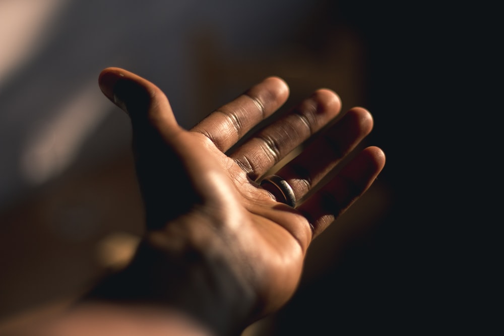 person wearing silver ring with black manicure