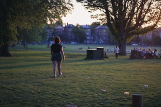 A man confidently walking through a city park during sunset, symbolizing personal growth.