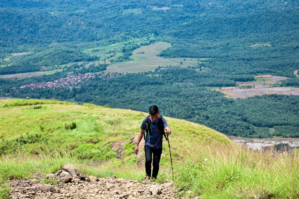 woman in black jacket and black pants with black sling bag standing on rocky ground during