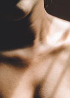 Close-up of hands expertly massaging shoulders with warm lighting.