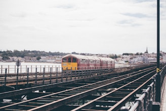 red and yellow train on rail during daytime