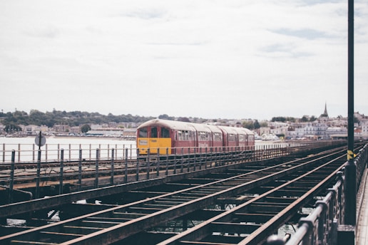 red and yellow train on rail during daytime