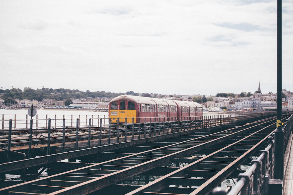 red and yellow train on rail during daytime