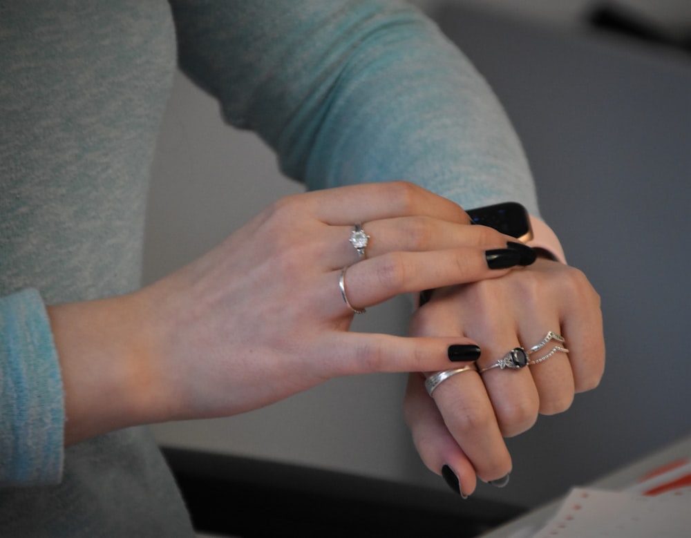 person wearing silver ring and gray pants