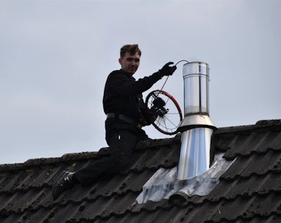 Close-up of a plumber fixing a roof gutter with tools.