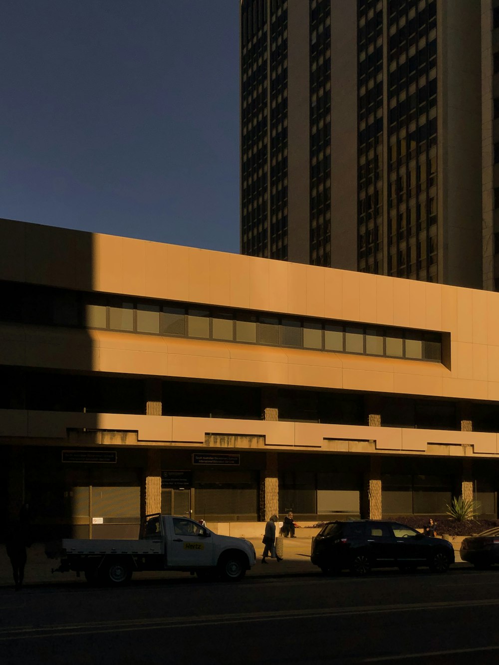 cars parked in front of brown building during night time