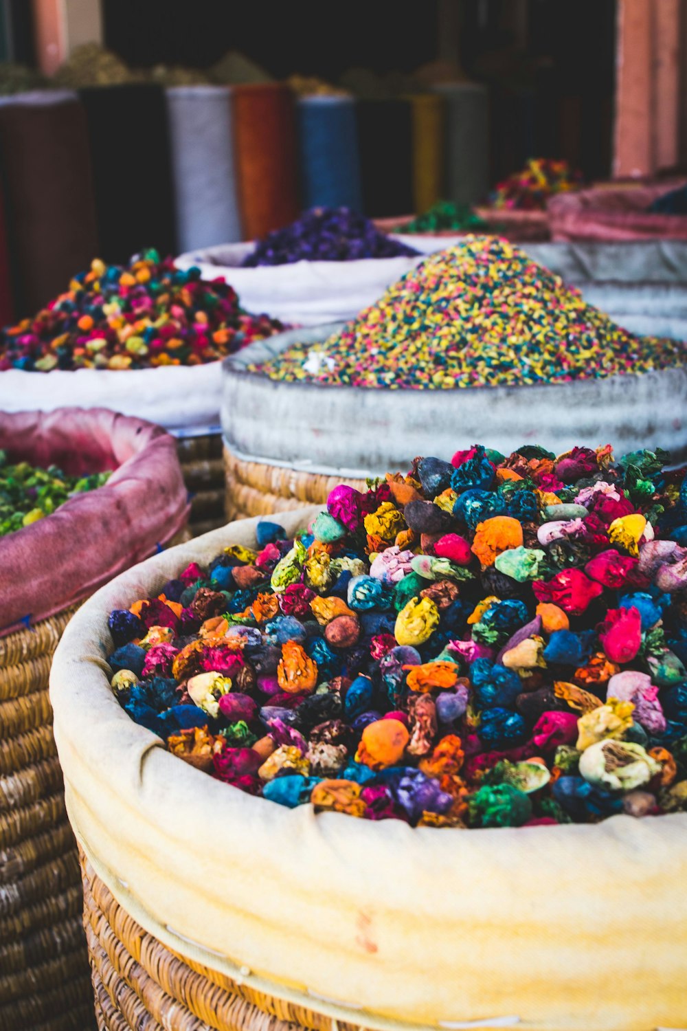 person holding brown wicker basket with assorted color candies