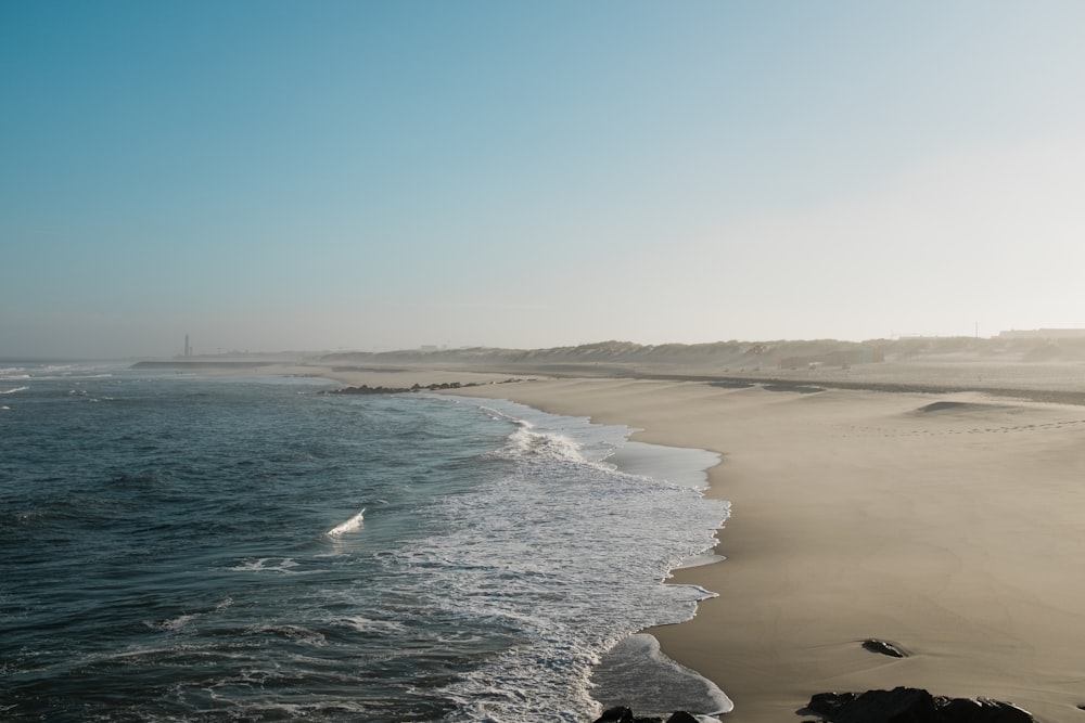 sea waves crashing on shore during daytime