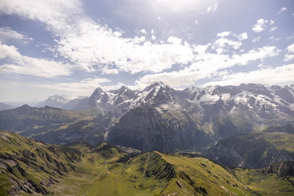 green and white mountains under white clouds and blue sky during daytime