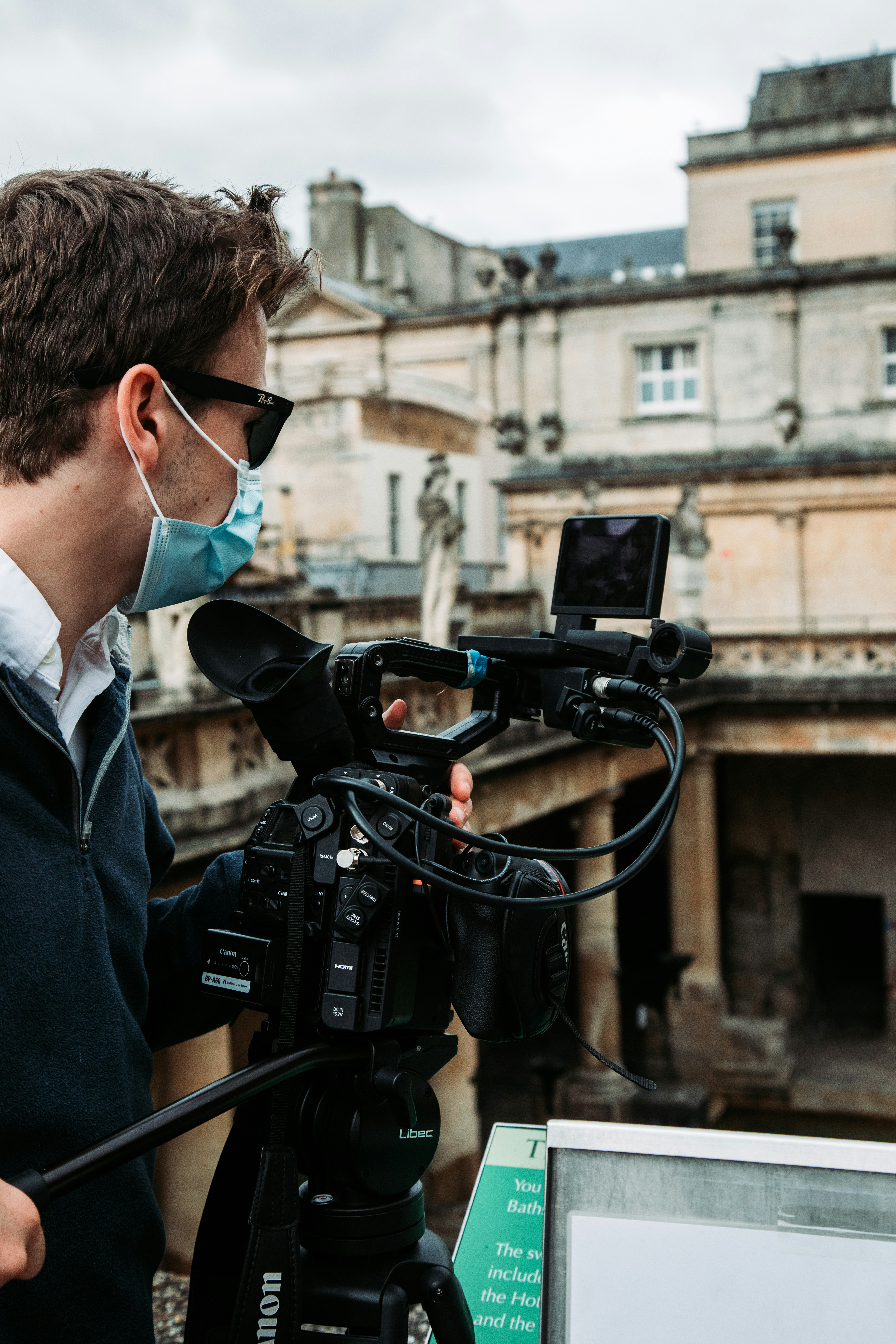 man in black suit jacket holding black video camera