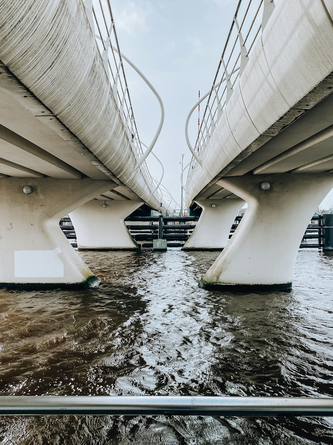 white boat on water under bridge