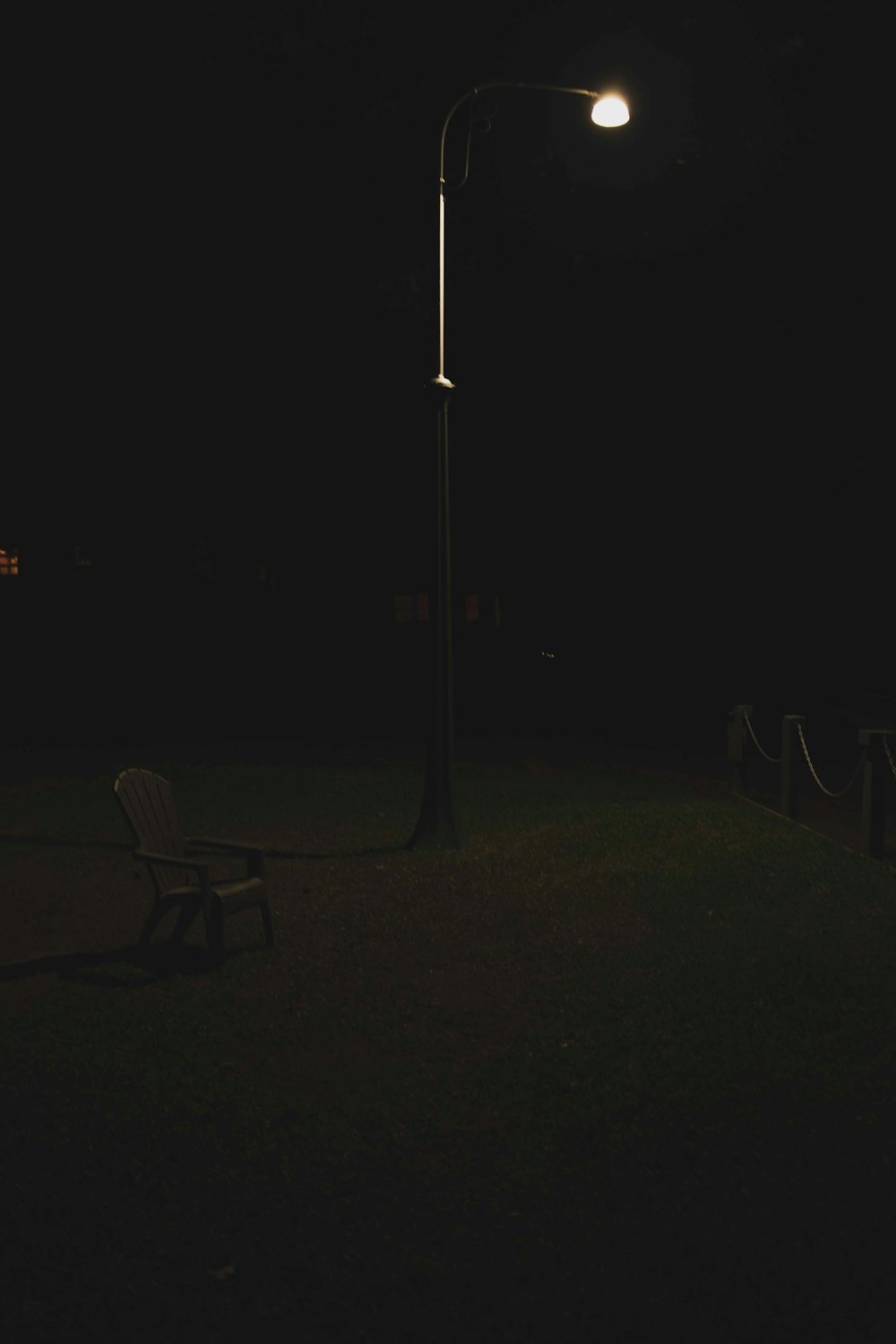 black metal chair near light post during night time