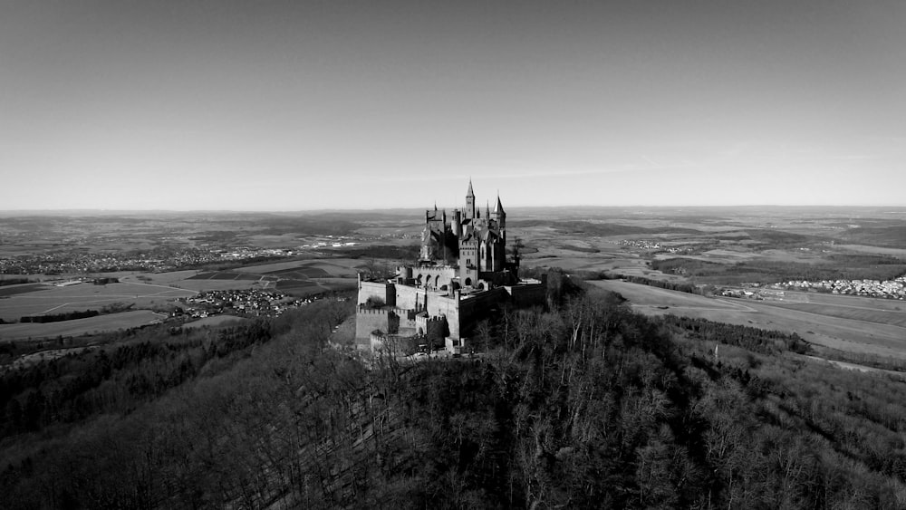 grayscale photo of castle on hill