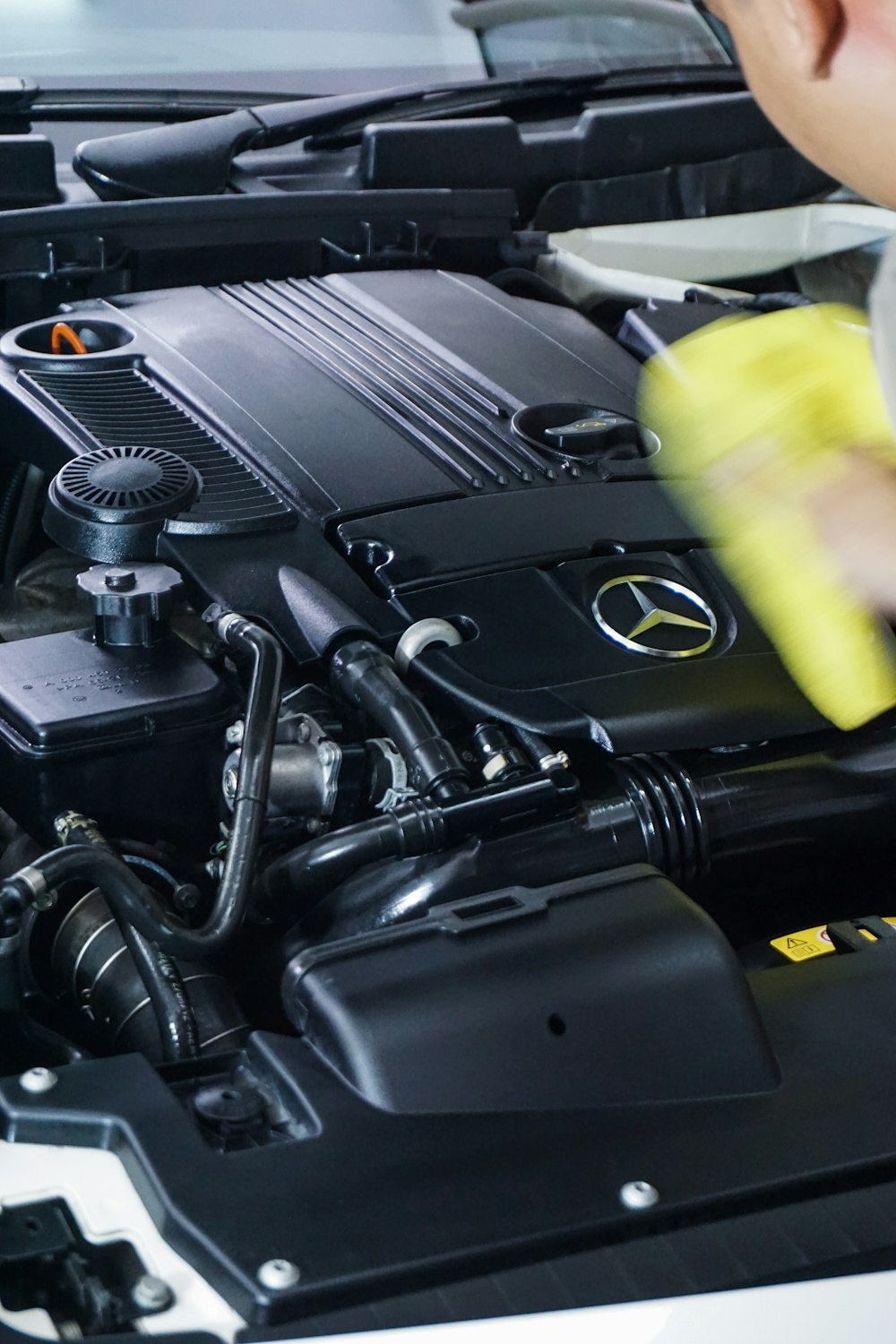 black car engine bay and yellow plastic cup