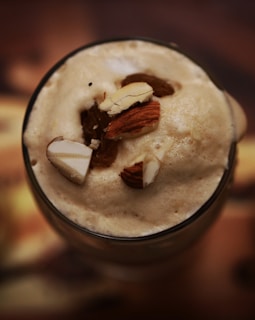 A glass of creamy, dairy-free bednog topped with a sprinkle of nutmeg.