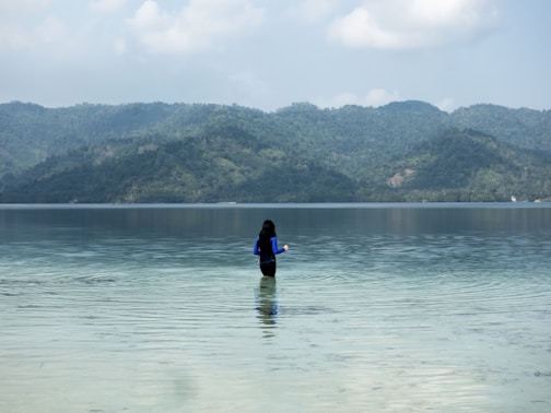 person in black wet suit on body of water during daytime