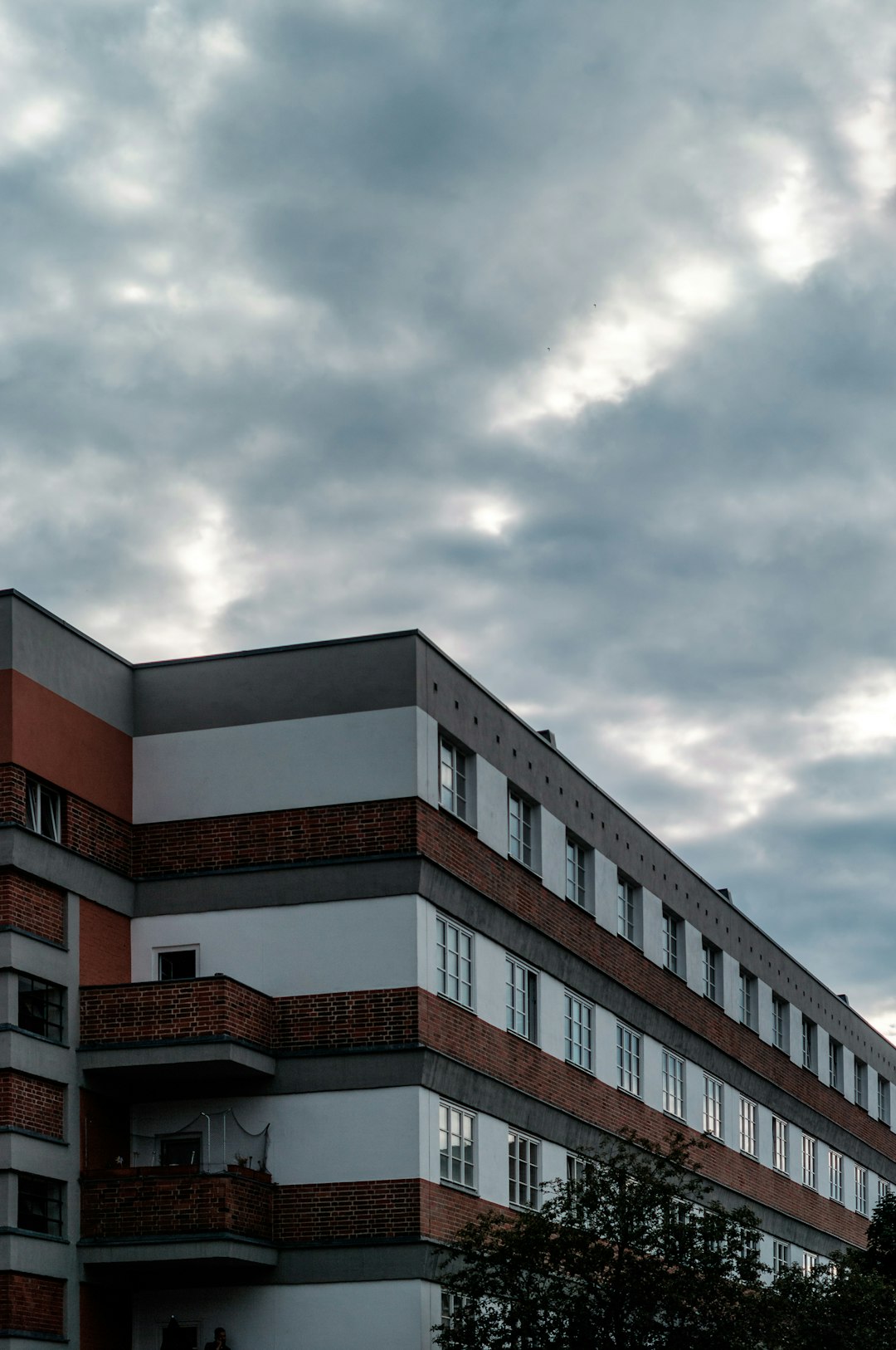 brown and white concrete building under white clouds