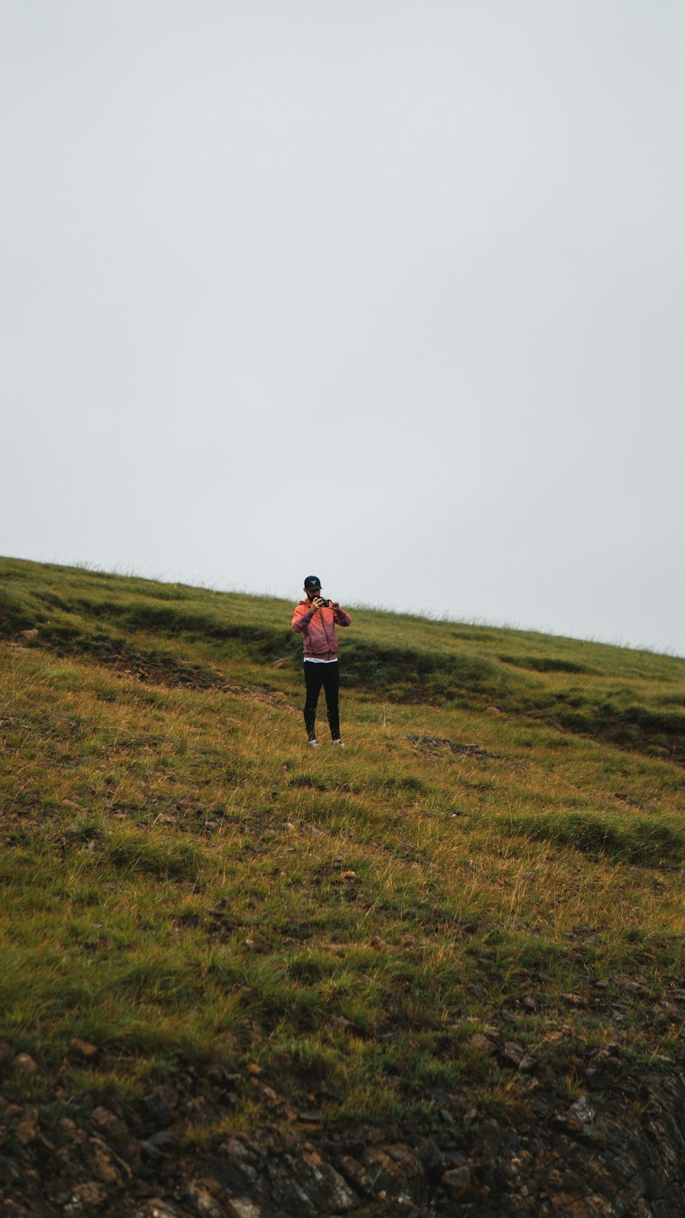 woman in black jacket standing on green grass field during daytime