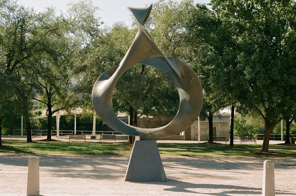 silver round statue near green trees during daytime