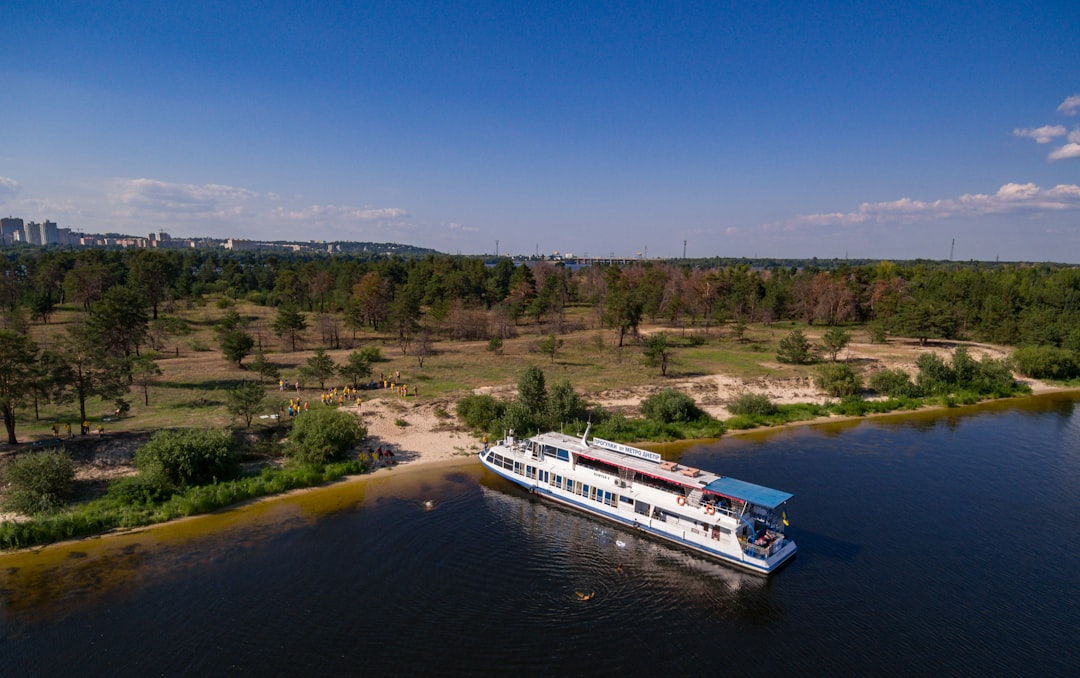 white and blue boat on river during daytime