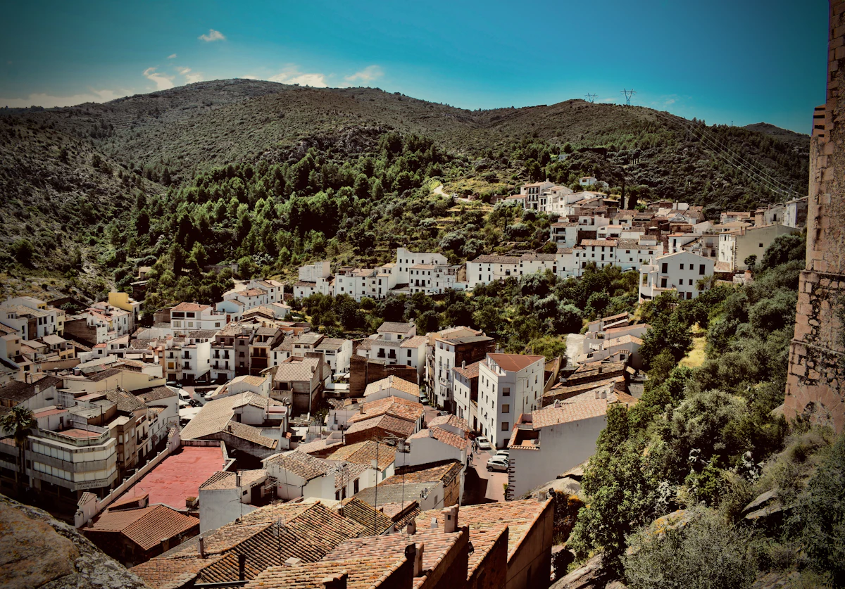 The hill village of Vilafamés, its white houses on a slope with green hills behind