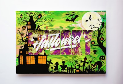 A Halloween-themed illustration featuring a haunted house surrounded by twisted trees with jack-o'-lanterns and spiders hanging from the branches. There's a large full moon with a witch flying on a broomstick, and several bats fill the sky. Silhouettes of gravestones, a cat with glowing eyes, and children in costumes are at the bottom. The word 'Halloween' is prominently displayed across the center with a stylized, vibrant design in purple and white.