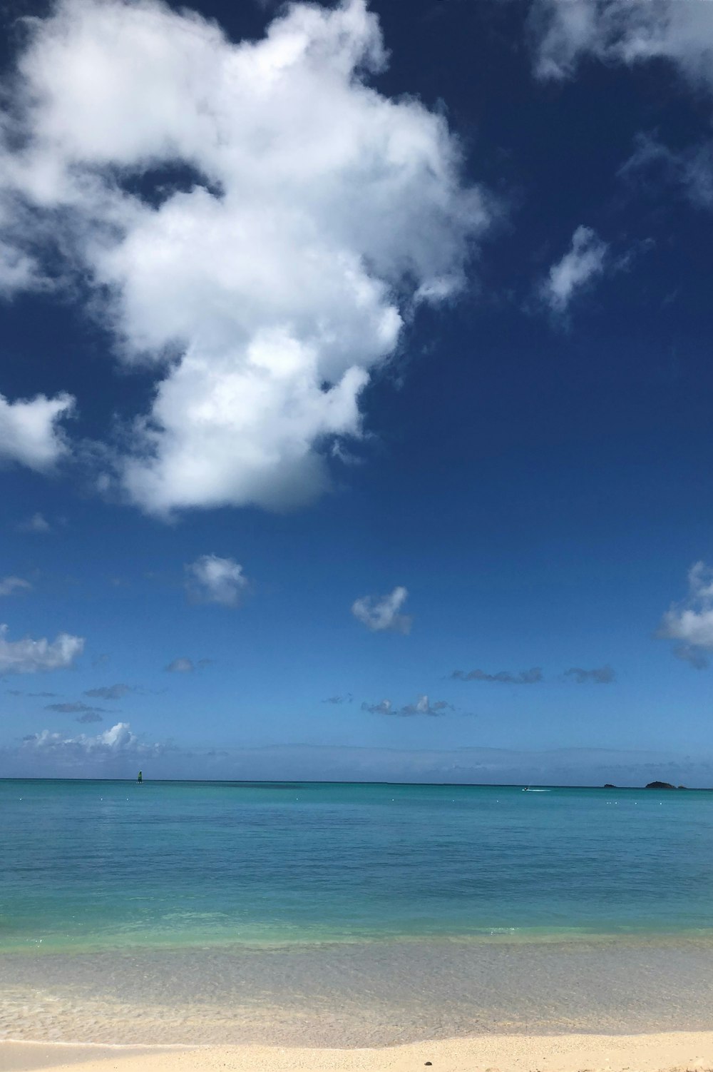 blue sea under blue sky and white clouds during daytime